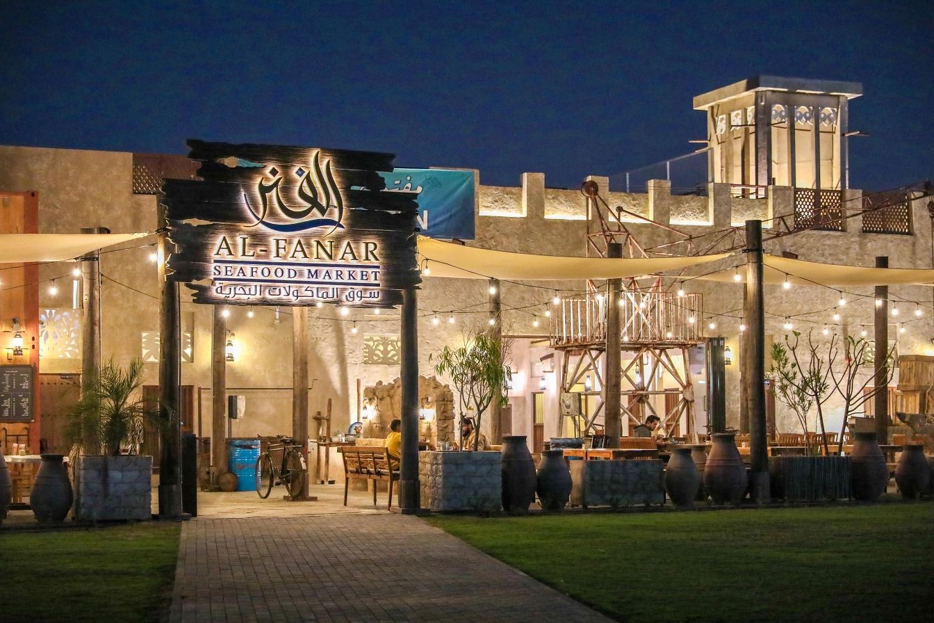 Al Fanar Seafood Market at Al Barsha Pond Park, lit up at night