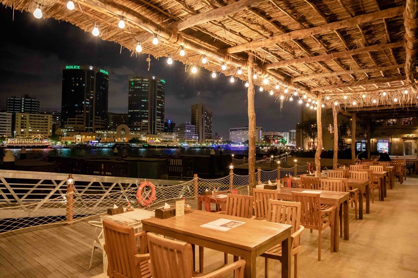 The Al Seef terrace at night, looking across Dubai Creek to the city